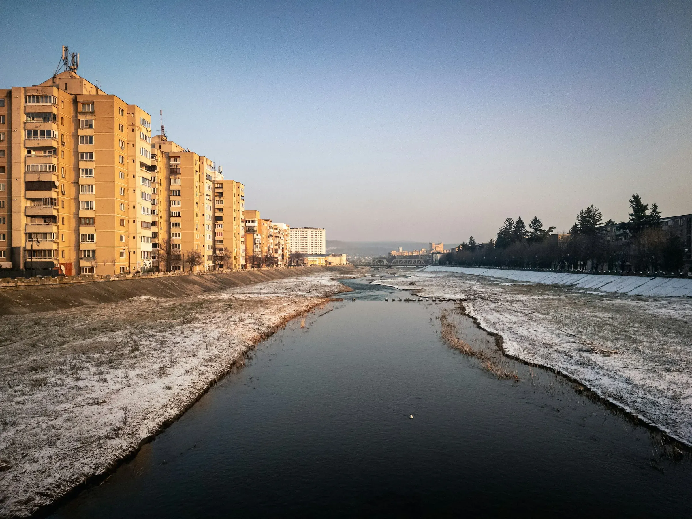Housing blocks along a frozen river, their balconies facing the water.